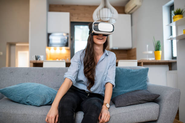 istock Young woman using VR headset in the living room 1125715021