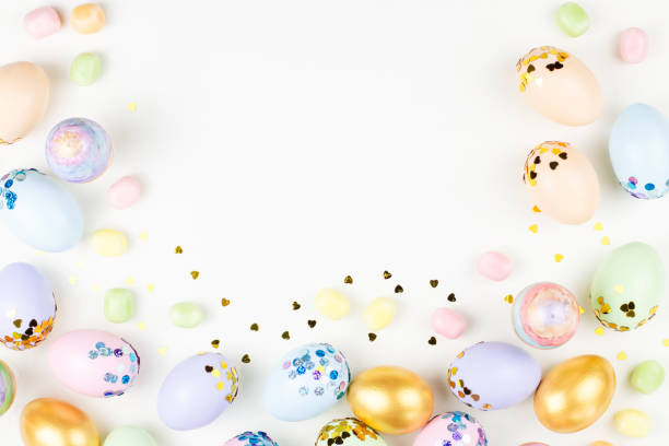 istock Festive Easter background with decorated eggs, flowers, candy and ribbons in pastel colors on white. Copy space 1125715131