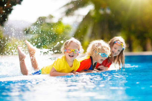 dzieci w basenie. dzieci pływają. rodzinna zabawa. - enjoyment people beach sun protection zdjęcia i obrazy z banku zdjęć