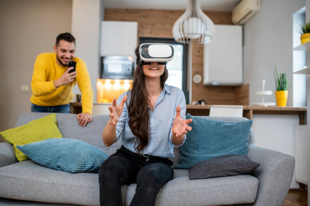 istock Young couple using VR headset in the living room 1125715254