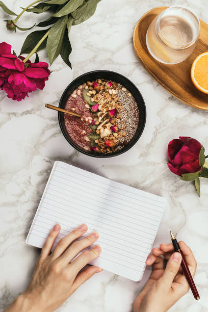 istock Flatlay of woman's hands with notebook and smartphone, vegan smoothie bowl with chia pudding 1125717455