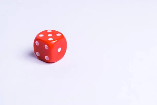 Photo of A red dice on a uniform background
