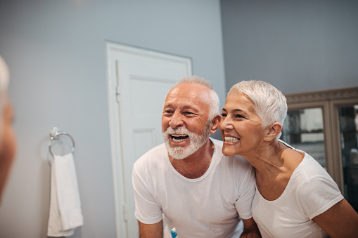 Cute mature couple brushing teeth