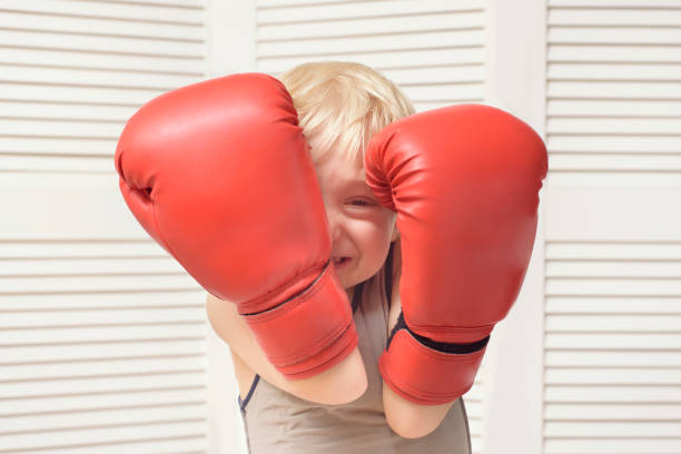 istock Blond boy is protected in two boxing gloves. Portrait 1125723041