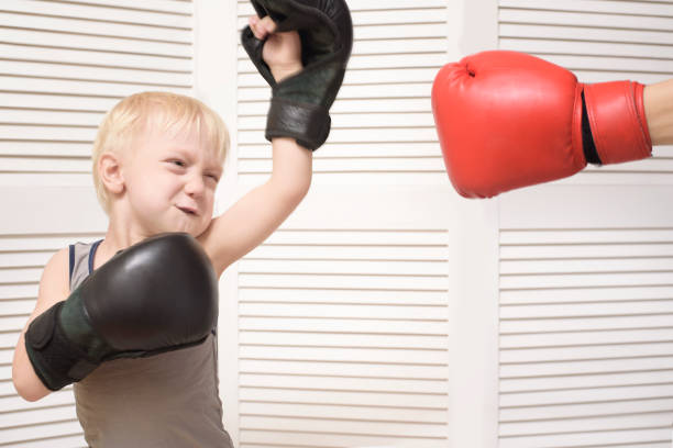 istock Blond boy boxing with hand in red glove. Emotions 1125723071