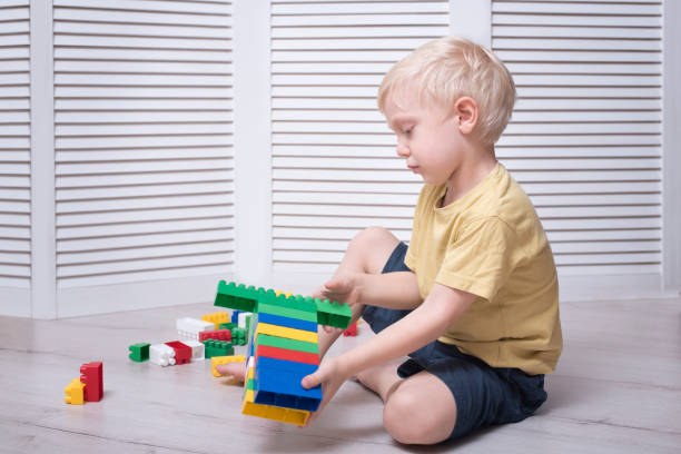 istock Little blond boy is building of colored designer 1125723107