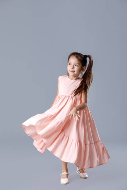 niña en vestido rosa posando sobre fondo gris. - ballet dress studio shot costume fotografías e imágenes de stock