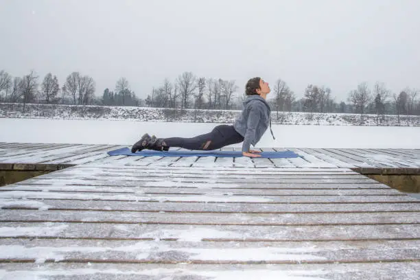 Woman does yoga on the icy and snowy lake
