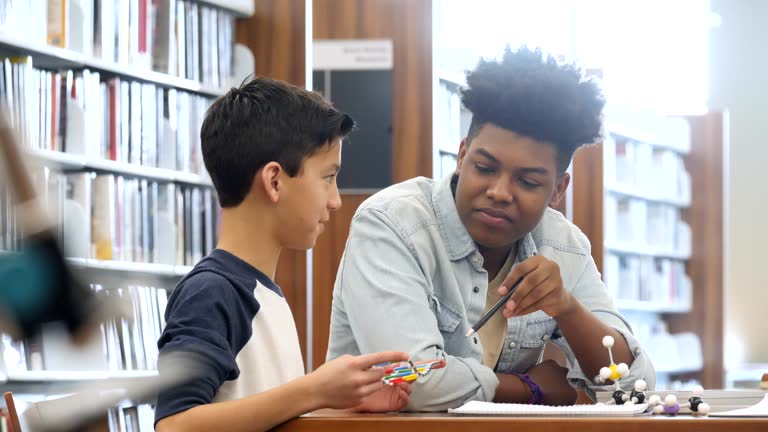 Teenage boy tutors middle school student