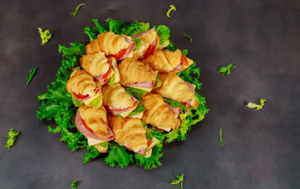 Croissant with sausage cheese and herbs. on dark background