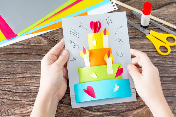 the child holds greeting card with birthday cake congratulation. children's art project craft for kids. craft for children. - 16607 imagens e fotografias de stock