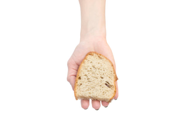 istock Woman's hand holding piece of bread. Isolated on white. 1125728626