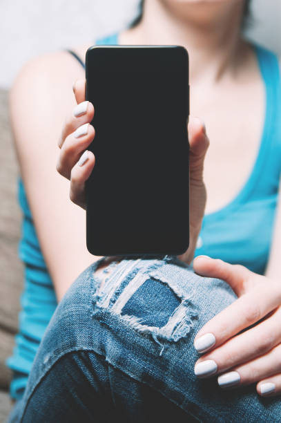 istock A woman holding a smartphone in her hands. Template for design or app 1125729606