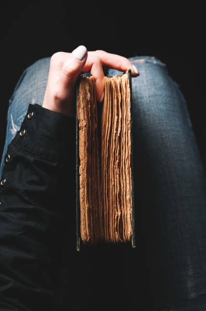 istock Woman holding an old book in her hands 1125729644