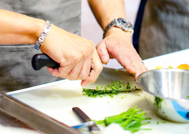 istock chopping green onion, Chef cutting fresh vegetables for cooking 1125731978