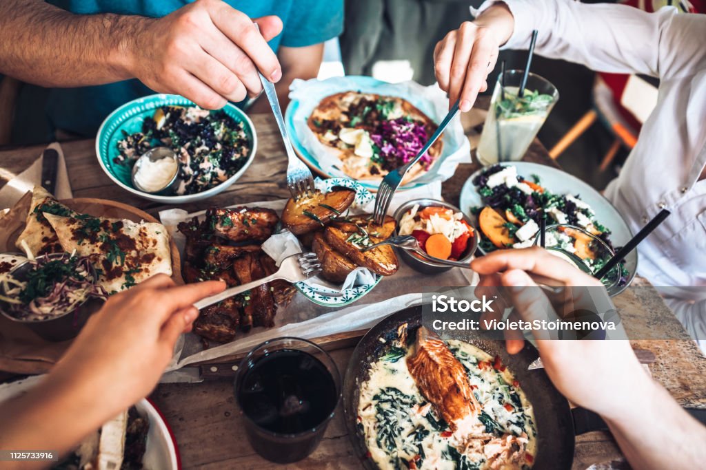 Enjoying lunch with friends Happy people sharing their healthy lunch Food Stock Photo