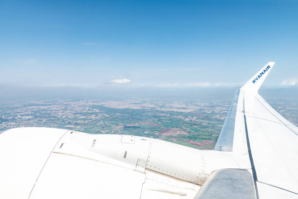 aerial high angle view on ryanair samolot skrzydło i silnik z okna na przedmieściach rzymu domów i mgła zanieczyszczenia nieba - ciampino airport zdjęcia i obrazy z banku zdjęć