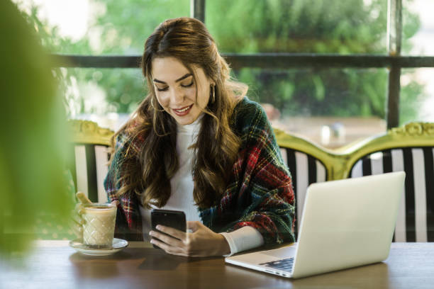 istock Young woman texting in coffee shop 1125736646