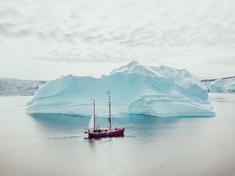 Photo from an expedition with a sailing boat through the beautiful vast landscape of huge icebergs and impressive mountainscapes in East Greenland.