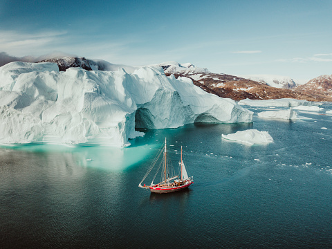 Photo from an expedition with a sailing boat through the beautiful vast landscape of huge icebergs and impressive mountainscapes in East Greenland.