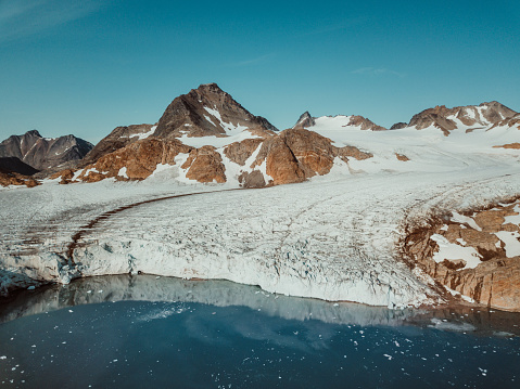 Photo from an expedition with a sailing boat through the beautiful vast landscape of huge icebergs and impressive mountainscapes in East Greenland.