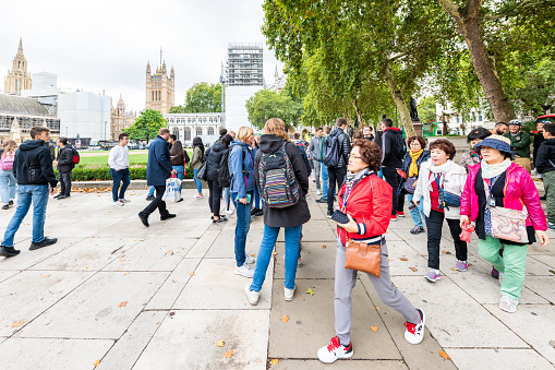 London, UK - September 12, 2018: Westminster area with Parliament Square Garden and crowd group of many people asian tourists walking during day