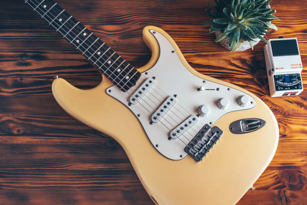 Beautiful yellow retro guitar on wooden table.