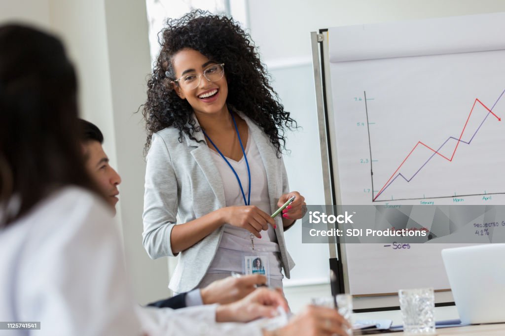 Junge Unternehmerin gibt Präsentation an Kollegen - Lizenzfrei Ausverkauf Stock-Foto