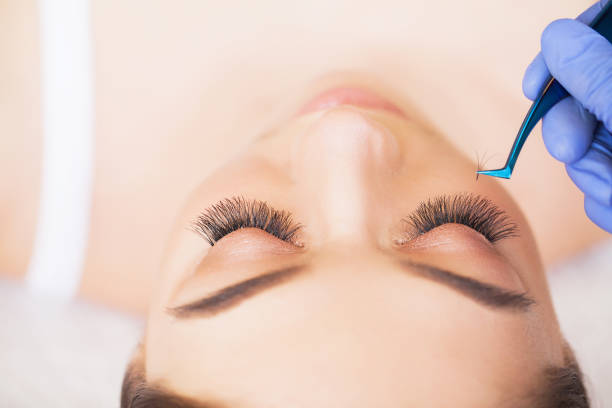 istock Eyelashes extensions. Fake Eyelashes. Eyelash Extension Procedure. Professional stylist lengthening female lashes. Master and a client in a beauty salon 1125742757