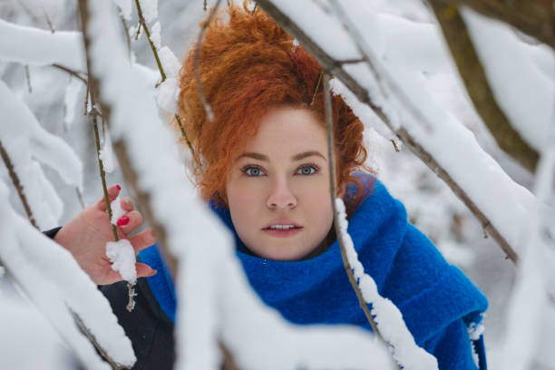 Young beautiful fashion woman in warm clothing enjoying outdoors in the winter forest