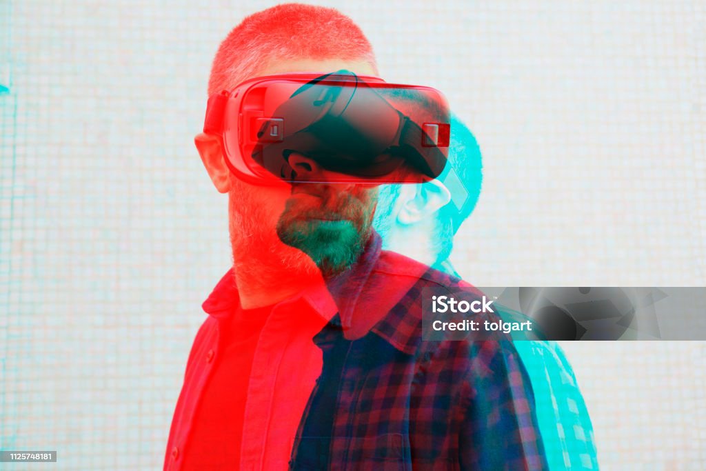 Hombre con casco de realidad virtual - Foto de stock de Simulador de realidad virtual libre de derechos