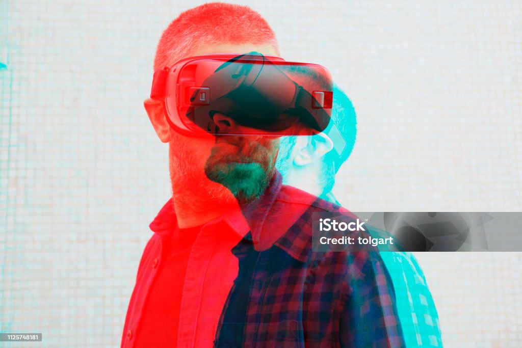 Uomo che indossa cuffie per la realtà virtuale - Foto stock royalty-free di Simulatore di realtà virtuale