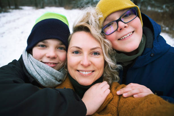 селфи красивой матери и двух сыновей-подростков в зимней одежде. - winter clothing hat human eye стоковые фото и изображения