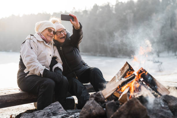 coppia senior che scatta selfie vicino al falò - snow nature sweden cold foto e immagini stock