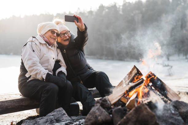 старшая пара делает селфи у костра - snow nature sweden cold стоковые фото и изображения