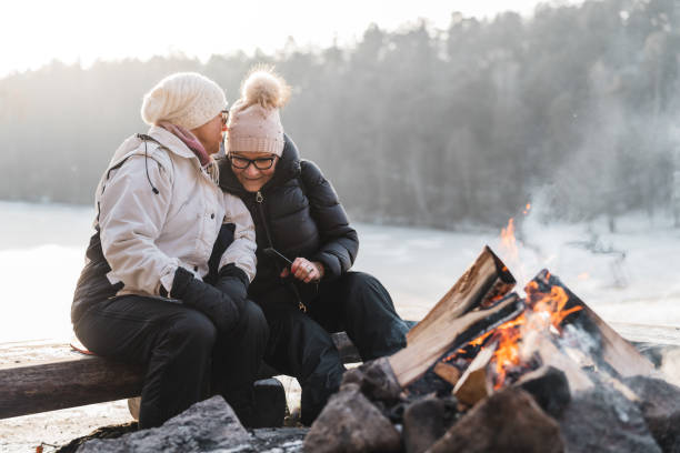 istock Senior couple taking selfies and whispering by the campfire 1125750544