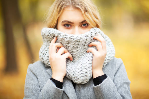 istock Cold autumn. Woman walking in park feeling cold 1125761631