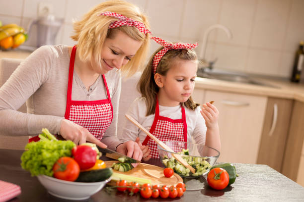 istock Mother and daughter making salad 1125762856
