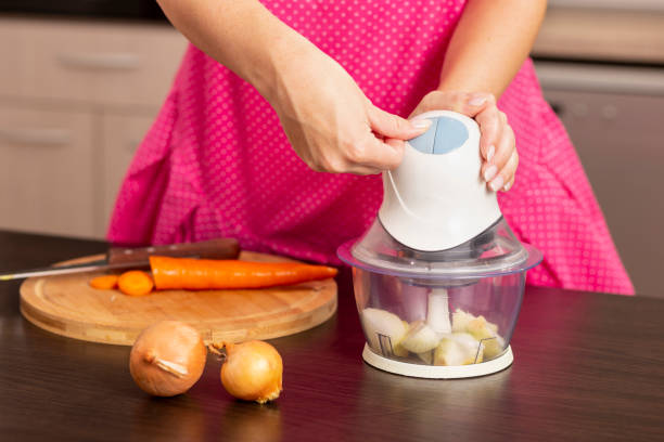 タマネギ チョッパーの回転の女性 - food processor ストックフォトと画像