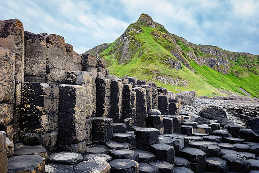 Beautiful Giants Causeway Volcanic Landscape with famous Hexagonal Basalt Columns under dramatic skyscape. Giants Causeway, Northern Ireland, UK