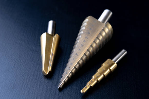 istock Conical drills on a workshop table. Accessories for mechanics to make holes. Dark background. 1125767927