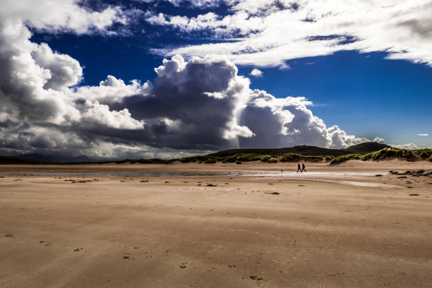 coppia con cane che cammina sulla spiaggia sabbiosa di achnahaird in scozia - great scottish run foto e immagini stock