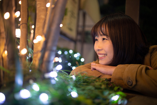 Young woman closely looking at Christmas lights