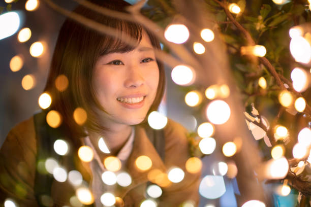 istock Young woman closely looking at Christmas lights 1125768914