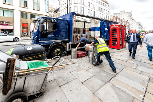 London, UK - September 12, 2018: Street road in the Strand in Covent Garden with delivery truck and people unloading kegs of beer for breweries and pubs
