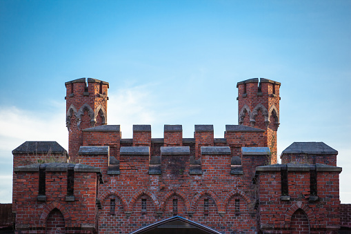well-preserved towers of the old medieval castle of red brick against a blue sky