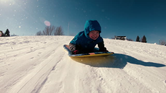 Young Boy Loves Snow Sledding