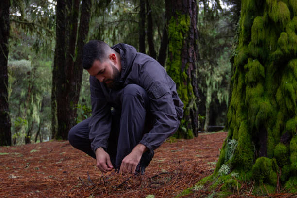 istock Hipster male model tying shoes in forest 1125777146