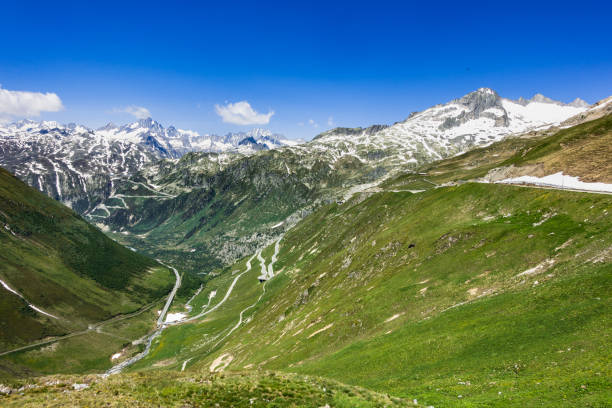 Summer landscape from Furka pass with the serpentine road climbing up the Rhone Valley and the Rhone Glacier on the right, Valais, Switzerland Summer landscape from Furka pass with the serpentine road climbing up the Rhone Valley and the Rhone Glacier on the right, Valais, Switzerland furka pass photos stock pictures, royalty-free photos & images