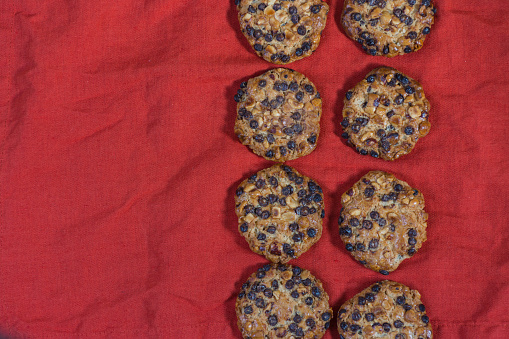 oats cookies with hazelnuts and chocolate chips on a red cloth